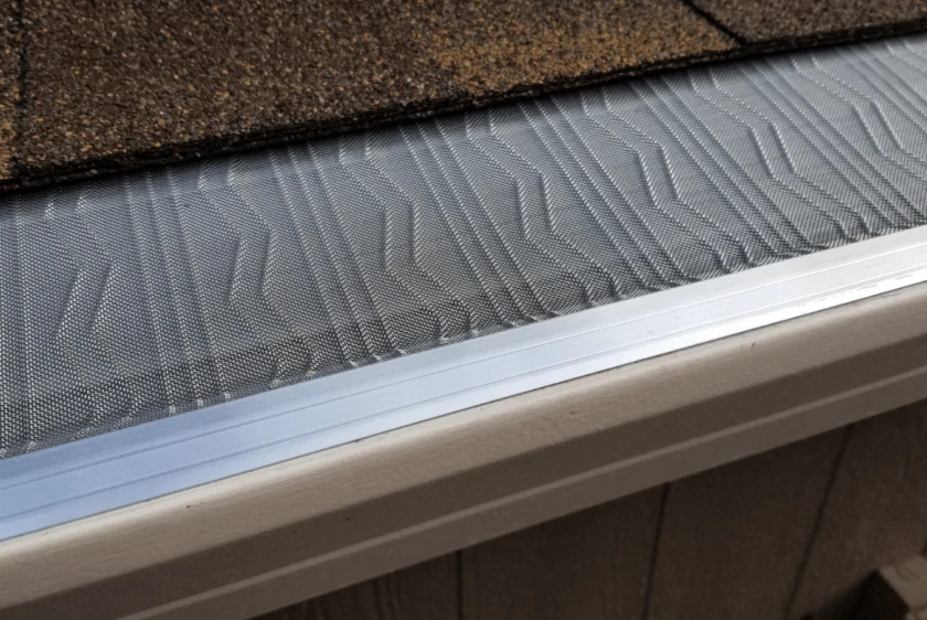 LeafBlaster Pro stainless steel micro-mesh gutter guard with a raised Z-Bend pattern beneath roof shingles.